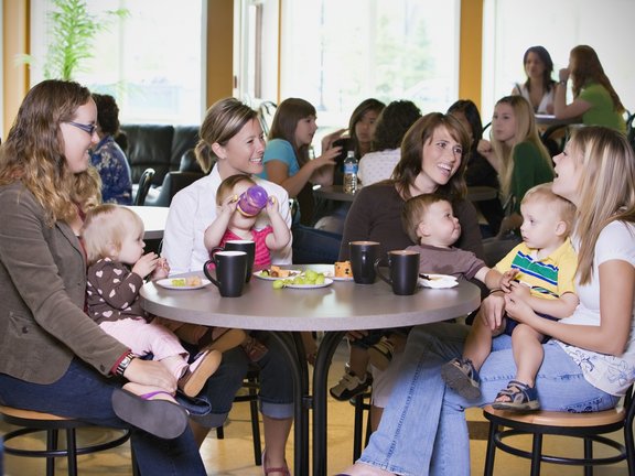 Group Of Young Mothers Relaxing In Cafe