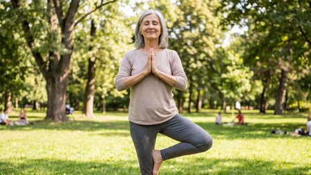 Senior woman practicing yoga tree pose outdoors in sunny park, mindfulness meditation, healthy aging and relaxation concept, lifestyle fitness and balance exercise in nature Image-45851
